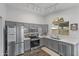 Bright kitchen with stainless steel appliances, grey cabinetry, and wood flooring at 3018 W Matthew Dr, Phoenix, AZ 85027