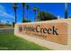 Community signage with the PebbleCreek Resort Community logo, set amongst palm trees and greenery at 3191 N 160Th Ave, Goodyear, AZ 85395