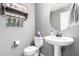 Powder room featuring a pedestal sink, oval mirror, and decorative shelving at 337 S Leandro --, Mesa, AZ 85208