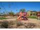 Community playground with a slide, swings, and climbing structures with a view of the neighborhood at 337 S Leandro --, Mesa, AZ 85208