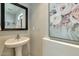 Stylish powder room with pedestal sink and decorative painting creating a charming and functional space at 3434 E Avalon Dr, Phoenix, AZ 85018