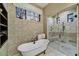 Luxurious bathroom showcasing a freestanding tub, patterned tile walls, and a glass shower at 37505 N 104Th Pl, Scottsdale, AZ 85262