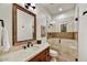 Elegant bathroom with a glass shower and a wood vanity with beige countertops and framed mirror at 37505 N 104Th Pl, Scottsdale, AZ 85262