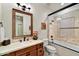 Bathroom boasting a tub-shower combo with a framed glass partition and neutral tile at 37505 N 104Th Pl, Scottsdale, AZ 85262