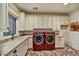 Well-equipped laundry room with ample counter space, custom cabinetry, and a modern washer and dryer at 37505 N 104Th Pl, Scottsdale, AZ 85262