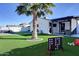 Landscaped backyard featuring artificial turf, a palm tree, and a covered patio with seating at 4026 N 81St St, Scottsdale, AZ 85251