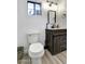 A well lit renovated half bathroom with wood look flooring and a rustic vanity at 4026 N 81St St, Scottsdale, AZ 85251