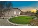 Twilight view of the home's backyard featuring artificial turf and desert landscaping at 4027 E Mark Ln, Cave Creek, AZ 85331