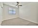 Bright, carpeted bedroom with a ceiling fan, and large window with horizontal blinds for natural light at 4027 E Mark Ln, Cave Creek, AZ 85331