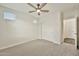 Carpeted bedroom with ceiling fan, and a double-door closet and open doorway to another room at 4027 E Mark Ln, Cave Creek, AZ 85331