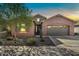 Charming home with stone accents, desert landscaping, and a two-car garage at sunset at 4027 E Mark Ln, Cave Creek, AZ 85331