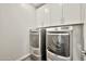 Modern laundry room with stainless steel washer and dryer and white cabinets above at 4027 E Mark Ln, Cave Creek, AZ 85331