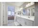 Stylish bathroom featuring dual sinks and a glimpse into the bright primary bedroom at 40440 W Haley Dr, Maricopa, AZ 85138