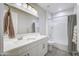 Bright bathroom featuring a tub/shower combo with white cabinets and a gray tile floor at 40440 W Haley Dr, Maricopa, AZ 85138