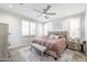 Comfortable bedroom with stylish ceiling fan, shutters, and a cozy upholstered bench at 40440 W Haley Dr, Maricopa, AZ 85138