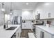 A modern kitchen with a center island, stainless steel appliances, and white cabinets at 40440 W Haley Dr, Maricopa, AZ 85138