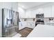 A modern kitchen with white cabinets, stainless steel appliances, and a quartz countertop at 40440 W Haley Dr, Maricopa, AZ 85138