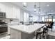 Modern kitchen with white cabinets, an island with pendant lighting, and stainless steel appliances at 40440 W Haley Dr, Maricopa, AZ 85138