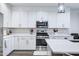 Bright kitchen featuring white cabinetry, stainless steel appliances, and a center island with a quartz countertop at 40440 W Haley Dr, Maricopa, AZ 85138