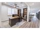 Home office with a wooden desk, shelving, and a neutral color scheme at 40440 W Haley Dr, Maricopa, AZ 85138