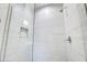 Modern shower with gray and white tiled walls, a recessed shelf, and chrome fixtures at 40440 W Haley Dr, Maricopa, AZ 85138