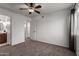 Bright bedroom features neutral carpet, a ceiling fan, and an adjacent bathroom at 461 W Holmes Ave # 277, Mesa, AZ 85210