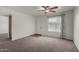 Bright living room showcasing plush carpeting, a ceiling fan, and a front-facing window at 461 W Holmes Ave # 277, Mesa, AZ 85210