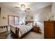 Inviting bedroom featuring a ceiling fan, side tables with lamps, and a shuttered window at 5350 E Deer Valley Dr # 2236, Phoenix, AZ 85054