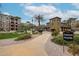 Beautiful apartments featuring lush landscaping with walkways and a palm tree against a partly cloudy sky at 5350 E Deer Valley Dr # 2236, Phoenix, AZ 85054