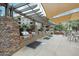 A row of clean stainless steel grills, with a stone backsplash, under a pergola with tables in the background at 5350 E Deer Valley Dr # 2236, Phoenix, AZ 85054