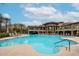 A large swimming pool with clear blue water surrounded by lounge chairs and palm trees on a sunny day at 5350 E Deer Valley Dr # 2236, Phoenix, AZ 85054