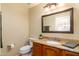 Cozy half-bathroom featuring vanity with granite countertop and decorative framed mirror at 5381 W Del Rio St, Chandler, AZ 85226