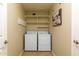 Functional laundry room with washer, dryer, shelving, and neutral wall color at 5381 W Del Rio St, Chandler, AZ 85226