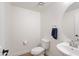 A half bath features a modern sink, round mirror, and a toilet with a tiled floor at 5824 E Hoover Ave, Mesa, AZ 85206