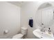 A half bath features a modern sink, round mirror, and a toilet with a tiled floor at 5824 E Hoover Ave, Mesa, AZ 85206