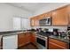 Well-lit kitchen featuring wood cabinets, granite countertops, and stainless steel appliances at 5824 E Hoover Ave, Mesa, AZ 85206