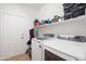 Functional laundry room with modern washer and dryer, storage shelf, and neutral tiling at 5824 E Hoover Ave, Mesa, AZ 85206