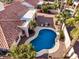 Aerial view of a backyard oasis with a pool and patio, surrounded by desert landscaping and palm trees at 6118 E Star Valley St, Mesa, AZ 85215