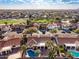 Aerial view of a neighborhood showcasing the golf course, community pool, and mature trees at 6118 E Star Valley St, Mesa, AZ 85215