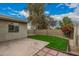 This backyard features a well manicured lawn, patio, block fence, and mature trees and flowering bushes at 619 E Jensen St # 80, Mesa, AZ 85203