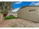 Side yard view with a decorative flower bush, small patch of grass, gravel and concrete patio at 619 E Jensen St # 80, Mesa, AZ 85203