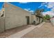 The side of a single-story stucco home showcases a secure, gated entrance and drought-resistant landscaping at 619 E Jensen St # 80, Mesa, AZ 85203