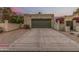 View of a home's one car garage and large driveway, with desert landscaping and an entry gate at 619 E Jensen St # 80, Mesa, AZ 85203