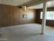 Cozy basement featuring wood paneling, carpet, and a vintage lamp providing a retro charm and extra living space at 6437 W Devonshire Ave, Phoenix, AZ 85033