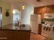 Bright kitchen with an island, white appliances, and views into an adjacent room at 6437 W Devonshire Ave, Phoenix, AZ 85033