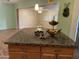 Close-up of a kitchen island with granite countertops and adjacent living space view at 6437 W Devonshire Ave, Phoenix, AZ 85033