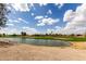 Golf course featuring a pond, green fairways, and residential homes in the background at 6634 S Pinnacle Ct, Chandler, AZ 85249