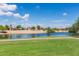 Scenic pond with a fountain surrounded by green grass and waterfront homes at 6634 S Pinnacle Ct, Chandler, AZ 85249