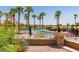 Sparkling pool with palm trees, desert landscaping, and distant views of lush golf course at 6634 S Pinnacle Ct, Chandler, AZ 85249