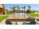 Beautiful water feature with palm tree reflections, green lawn and Adirondack chairs to relax in at 6634 S Pinnacle Ct, Chandler, AZ 85249